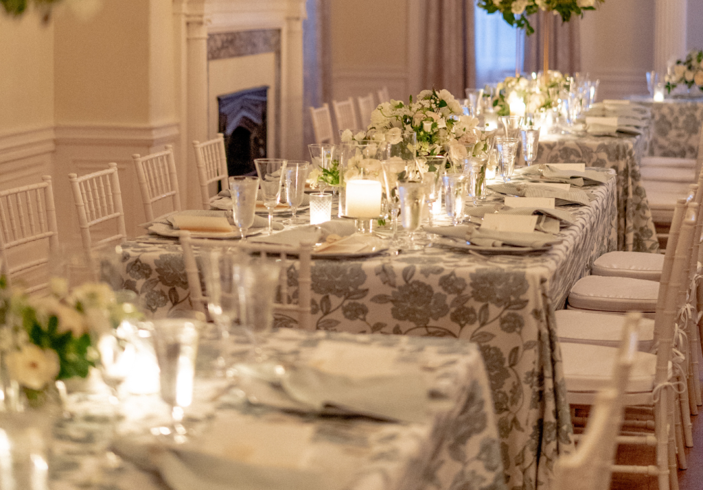 Long reception table styled with candles and floral centerpieces.