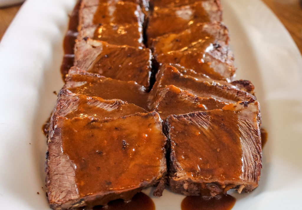 Braised short ribs served as an entrée during a luxury wedding reception.