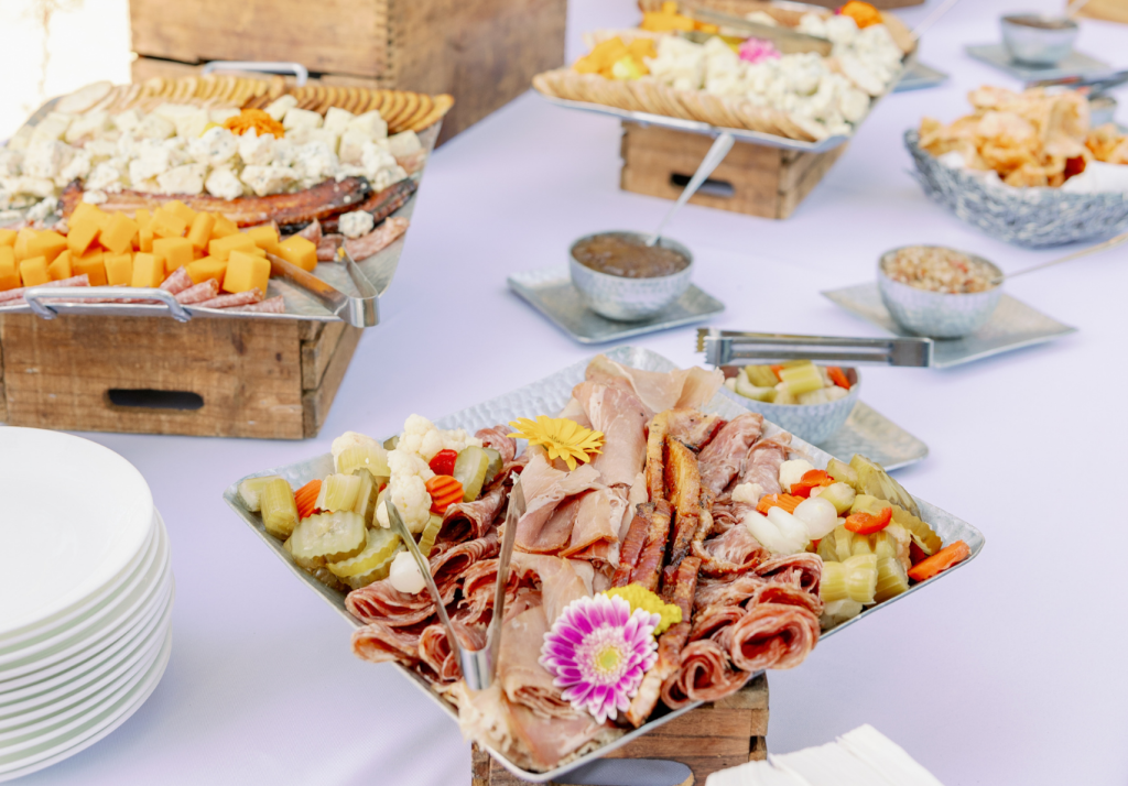 Elegant charcuterie grazing table with meats, cheeses, fruits, and appetizers.