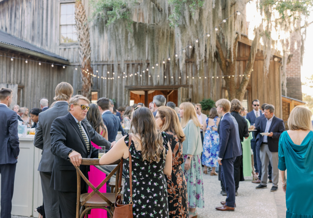 Wedding guests gathered for an outdoor reception beneath Spanish moss.