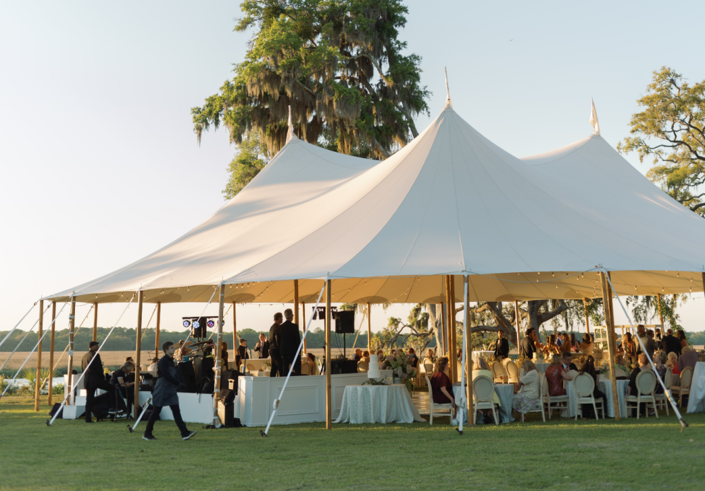 Large white sailcloth tent set for an outdoor Charleston wedding reception.