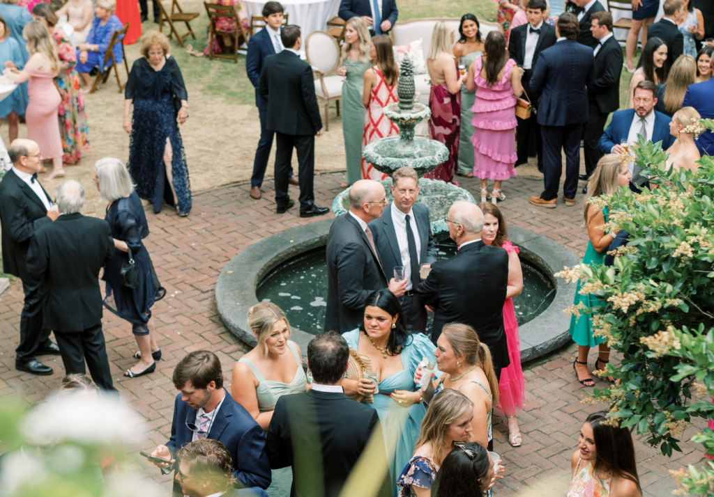 Wedding guests mingling during cocktail hour at an outdoor Charleston celebration.