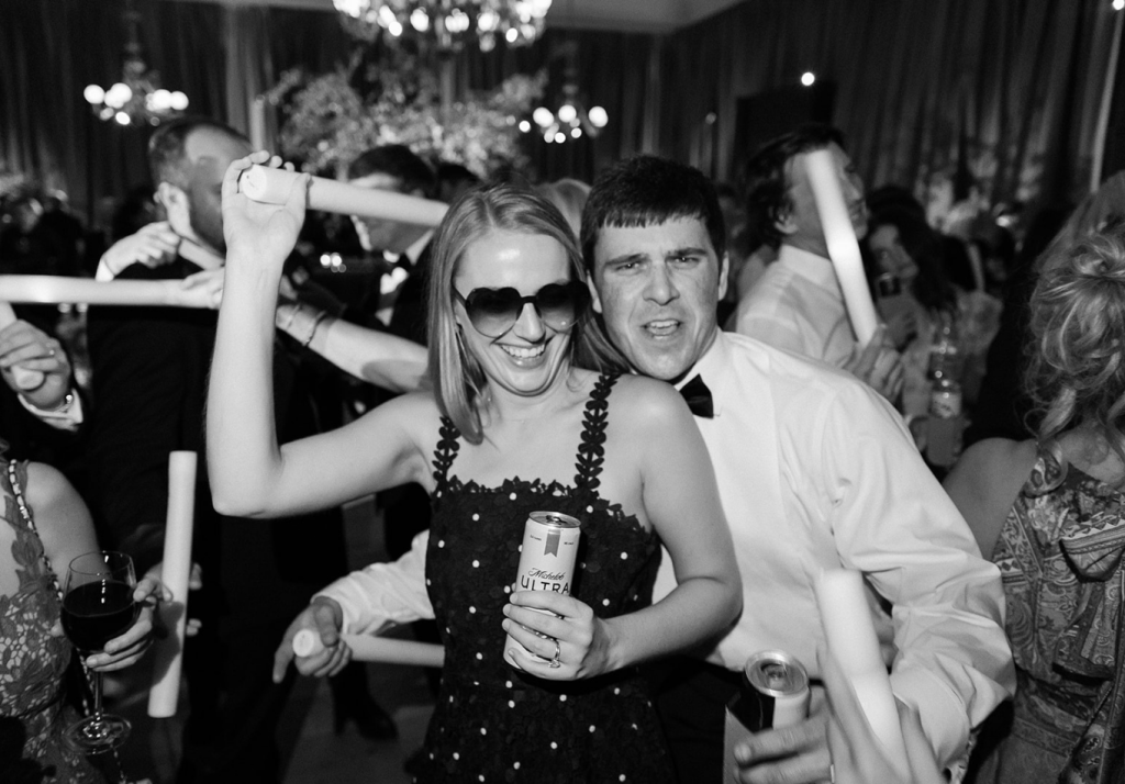 Wedding guests celebrating together on the dance floor during the reception.