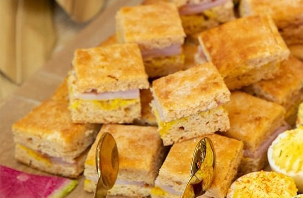 Serving ham biscuit appetizers for a catered holiday gathering